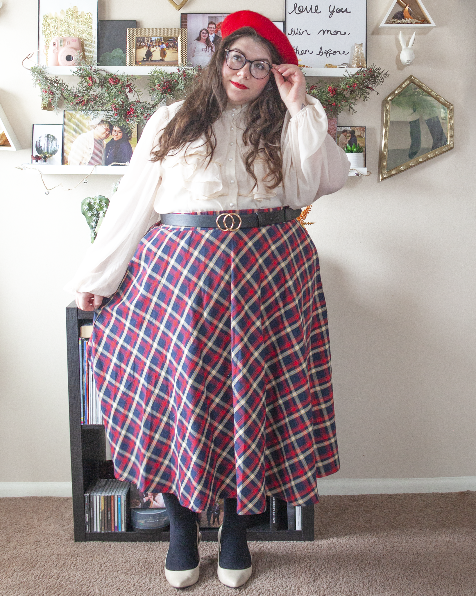 An outfit consisting of a red beret, a cream Regency era inspired high neck button down ruffle bodice blouse with sheer bishop sleeves tucked into a red and blue plaid midi skirt, black tights and cream slingback heels.