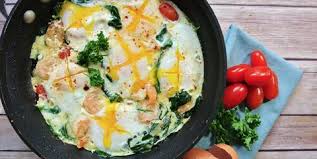 Fried eggs with tomatoes, cheese and grass.