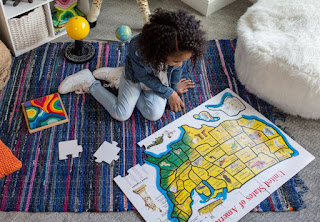 A little girl looks at a map of the United States