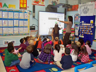 Kids and teacher using a SMARTboard in the classroom