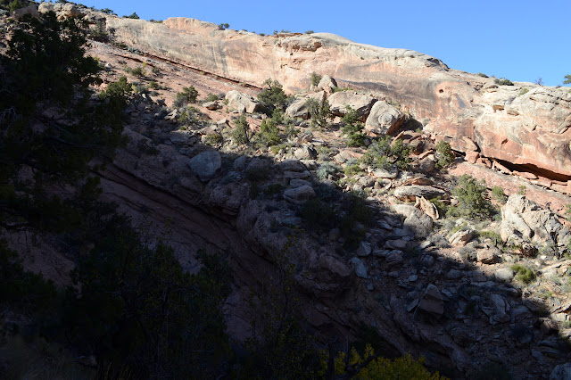 far edge of mooth rock layer with broke rocks below