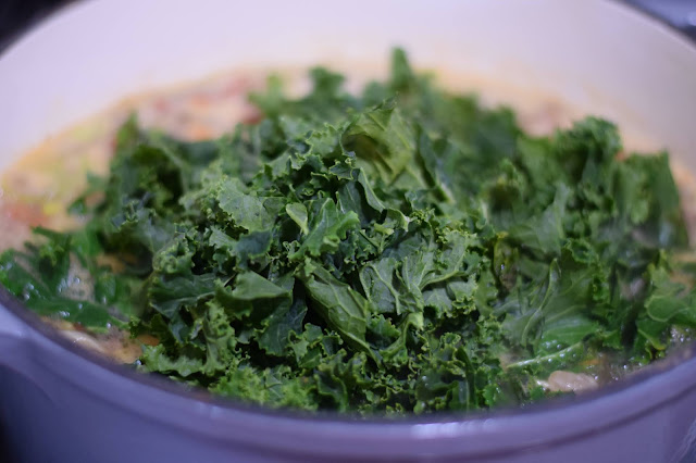 Kale being added to the pot.