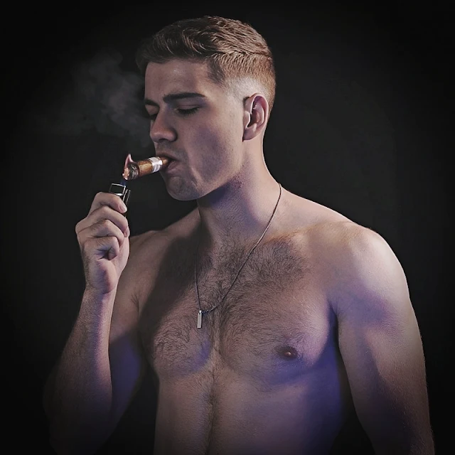 From the stomach up shirtless lighting a cigar and dude in his twenties