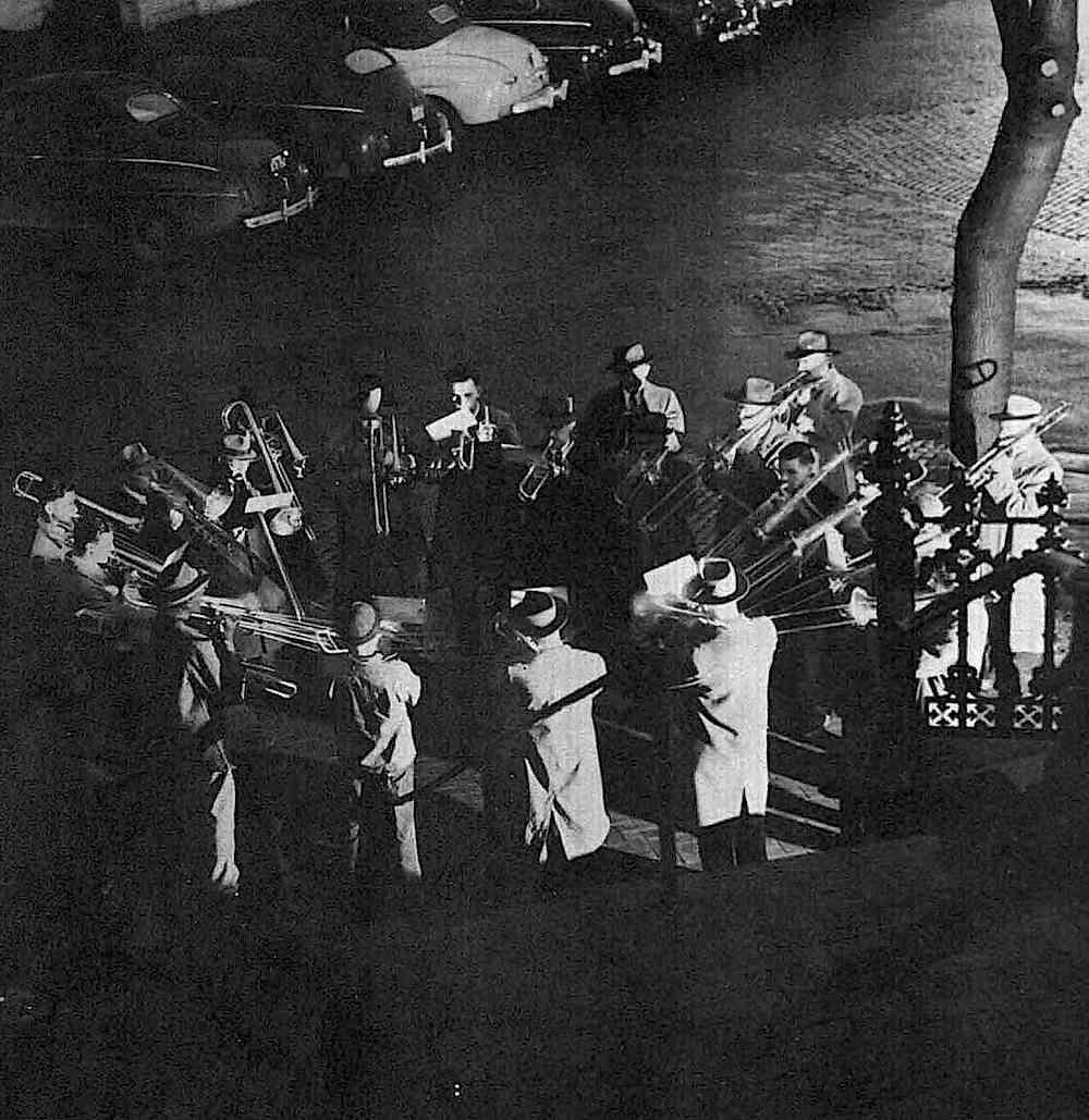 a 1957 photograph of a ring of trombone players at night