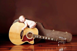 Gratis foto bayi lucu tidur di atas gitar