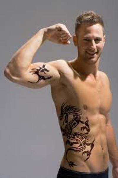 A tribal dragon tattoo on man's right rib Dragon Tattoos