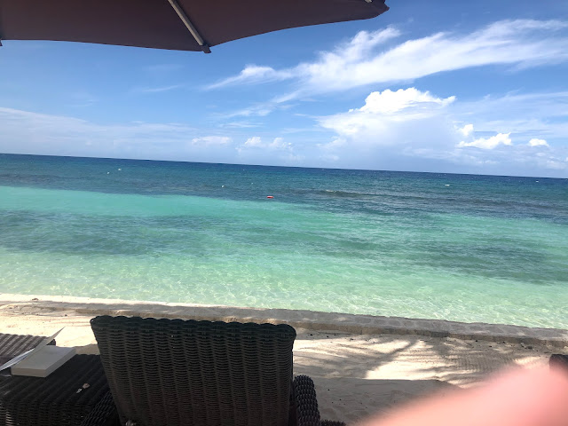 A beach lounger is in front of the stunning clear water of the Caribbean.