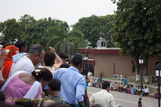 People not sitting, causing a blocking of the view at the Wagah Border between India and Pakistan