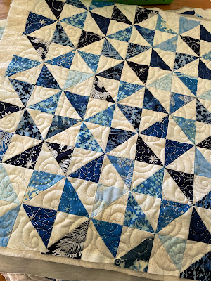 Blue and white batik triangles quilted in a swirl pattern