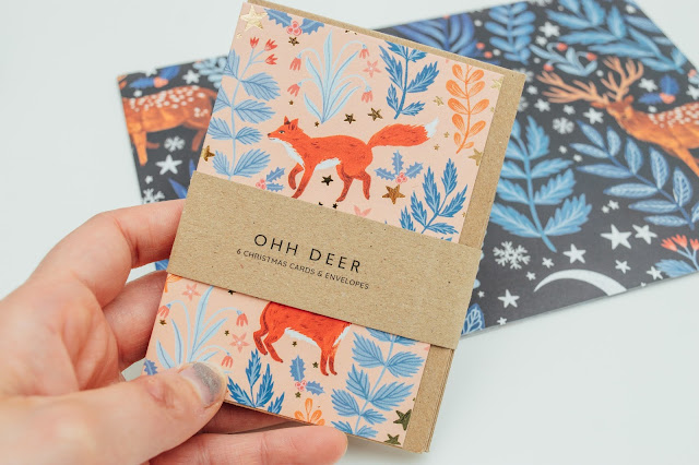 A pack of Christmas cards with foxes and a floral print all over