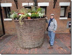 Elaine at a large flower pot near the Gloucester Waterway Museum
