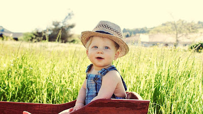 smiling-babu-with-hat-sitting-in-the-farm-pics