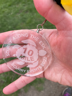The glass medal with a turtle on it and it says Scurry along the Esk 10 miles.