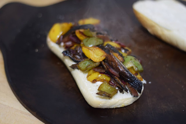 The mushroom philly mixture being added to the bun.