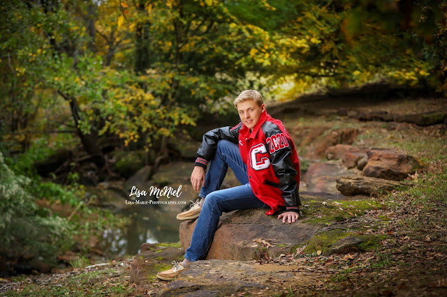 high school boy with letter jacket sitting in organic setting