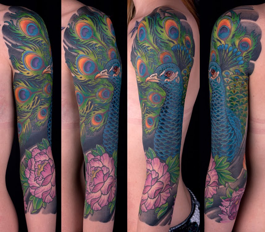 This peacock tattoo is covering almost a full half sleeve of a tree
