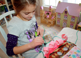 Using a newly mastered skill, Tessa tied on multi-colored yarn for hair.