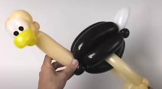 mehrfarbige modellierballons zu einer tierfigur des straußes modelliert.