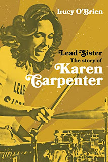 Book cover of Lead Sister. It's yellow and has a big photo of Karen Carpenter playing the drums.