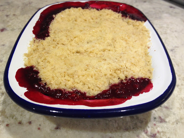 Red fruit crumble in blue and white enamel dish