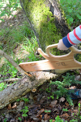 Kinder spielen im Wald mit ihren selbstgebauten Motorsägen aus Holz.