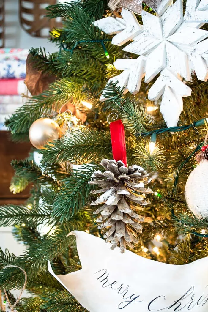 frosted pine cone hanging on Christmas tree