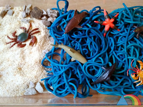 Mini mundo marino hecho con pan rallado y espaguettis teñidos de azul