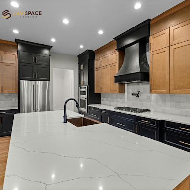 Modern kitchen with white marble island, black and wood cabinets, and stainless appliances