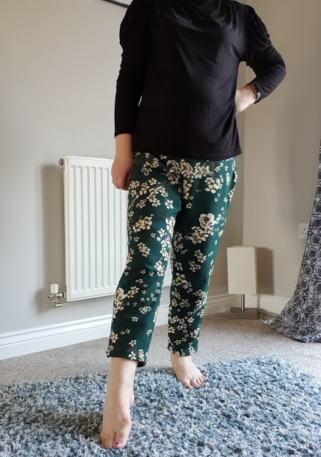 Sewn trousers modelled in front of grey wall