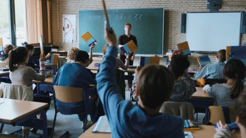 Students in a classroom raise their hand