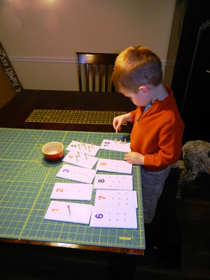 DIY Peg Board Game: Young boy putting pegs on cards 1 thru 10