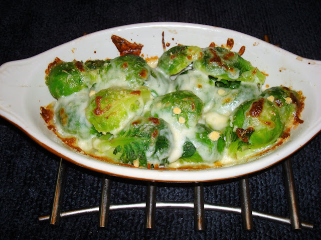 PORCIONES: 2 INGREDIENTES 340 g / 12 oz. de repollitos Bruselas 1 cucharada de mantequilla ½ taza de queso Mozarela rallado ¼ taza de queso Parmesano Sal y pimienta a su gusto PROCEDIMIENTO Cortar un poquito del final del tallo si es que está descolorido. Sacar las hojas que estén dañadas. Partir por la mitad a lo largo los repollito. En la parte final del tallo dar un pequeño corte a lo largo del tallo par que sea más fácil cocinarlos. Poner a hervir una olla con agua un poquito de sal y la mantequilla. Una vez que hierve poner los repollitos a cocinar, tape la olla y una vez que el agua vuelve a hervir sáquelos del agua y póngalos en pocillos de hornear. Agregue queso mozarela y Parmesano por encima. Ponga los pocillos en el horno a fuego alto o broiler y déjelos a cocinar hasta que queden dorados por encima.
