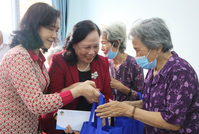 Đồng chí Phạm Thị Hải Chuyền (áo đỏ) trao quà NCT tại quận. (Ảnh Hải Linh)
