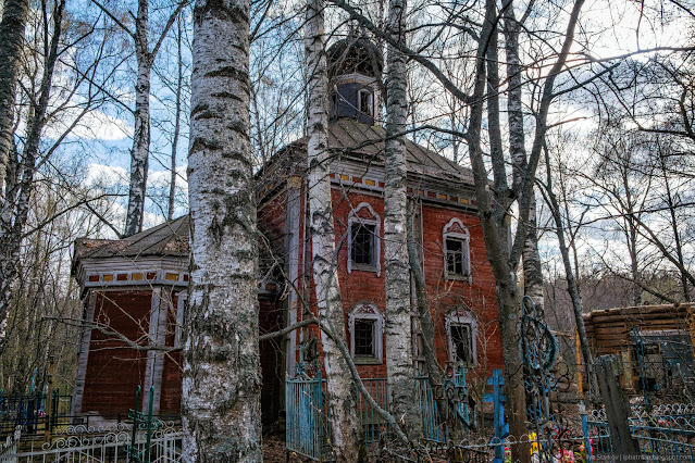 Деревянная церковь за стволами деревьев
