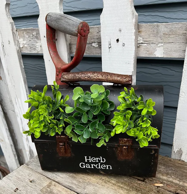 Photo of vintage metal lunchbox repurposed as an herb planter.