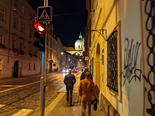 picture of people walking down city street at night