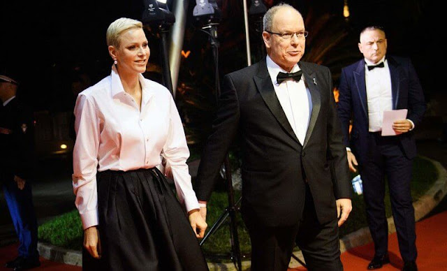 Princess Charlene wore a white silk shirt by Akris, and black pleated wide-leg skirt by Brunello Cucinelli. Dior pearl tribales earrings