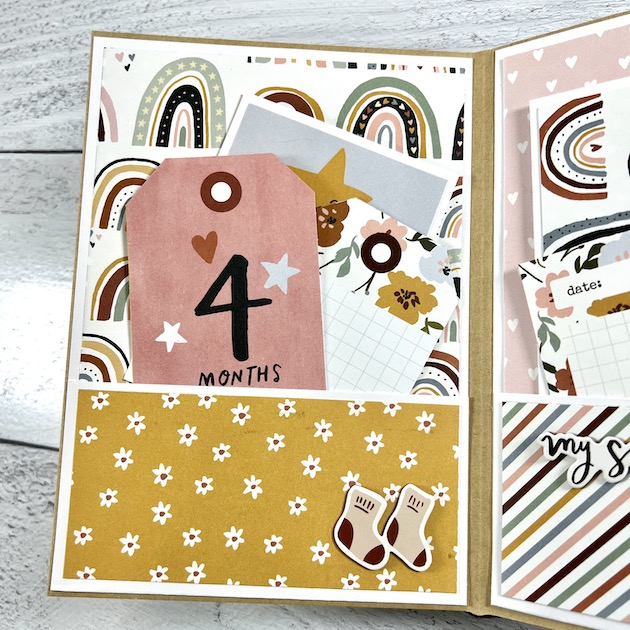 Baby scrapbook album page with a pocket, rainbows and flowers