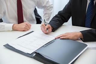 Two people looking over a contract | Collection services Michigan