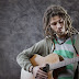 A young man plays guitar melodies