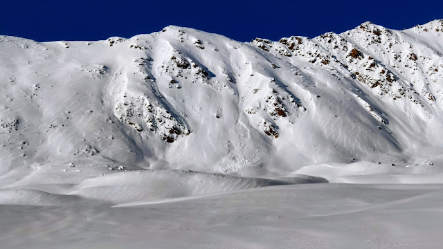 Schneedünen in Langtaufers sind eindeutige Anzeichen für Windeinfluss. In der Mitte des Bildes sieht man außerdem die Ablagerung einer alten Lawine. (Foto: Josef Plangger, 16.01.2023)