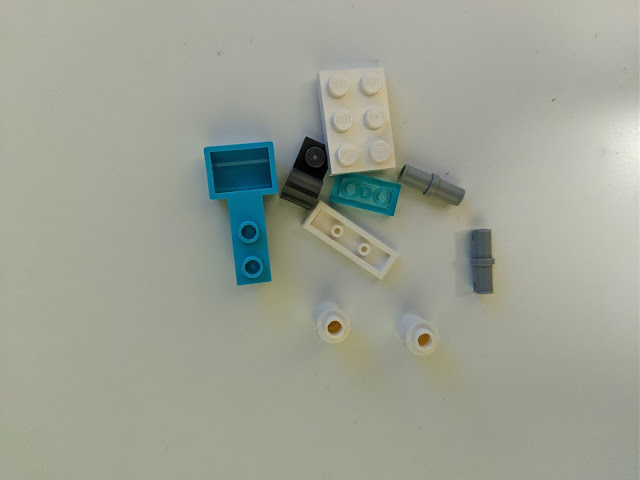 Picture of the opened parts bag. There are 9 parts in the bag, but one of the connector pegs is just a spare.
