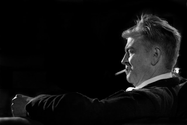 David Lynch sitting back on a chair