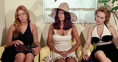 In a scene from the immoral three, three women, wearing low-cut dresses, sit in an office.