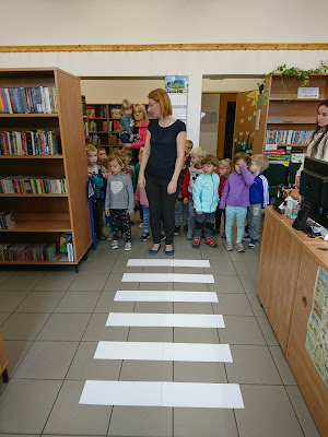 Na zdjęciu bibliotekarz pokazujący jak przechodzić przez pasy