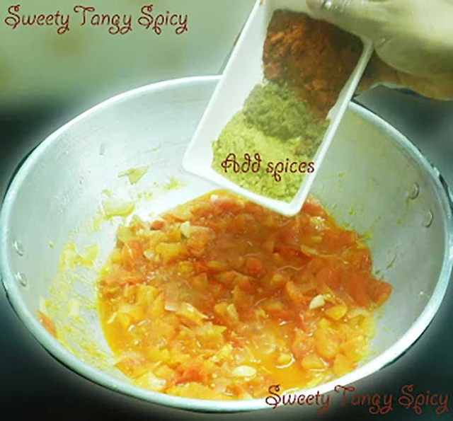 Spice powders being added to the soft and juicy tomato gravy.