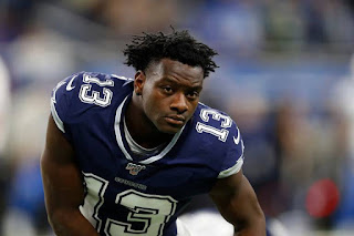 Michael Gallup -  é um grande jogador de futebol americano do Dallas Cowboys da National Football League.   Ele jogou futebol americano universitário na Universidade Estadual do Colorado.   Nasceu em  4 de março de 1996  em Atlanta, Geórgia, EUA. Altura: 1,85 m e Peso: 93 kg.  Descrição: Foto em fundo desfocado de Gallup da cintura para cima. Ele é um homem negro, porte atlético, braços torneados pela musculatura. O rosto  é quadrangular, cabelo com corte estiloso,raspados nas laterais e dreads no topo, testa alta e franzida, sobrancelhas espessas, olhos amendoados cor de jabuticaba, nariz anguloso e largo, e lábios carnudos. Gallup usa uma camiseta azul escuro do uniforme do Dallas, com o número 13 estampado em branco nos ombros e na parte frontal. Ele está com o corpo levemente inclinado à frente, e olha atento para frente.