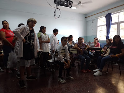 Foto 10: Alumnos, alumnas, padres y madres observando el video proyectado en la pizarra digital interactiva