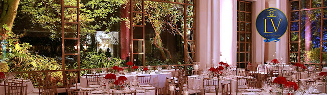 salón con ventanas, mesas con manteles claros y arboles al fondo