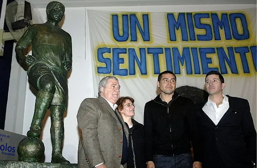 Juan Román Riquelme poses with his statue at the Museo de la Pasión Boquense